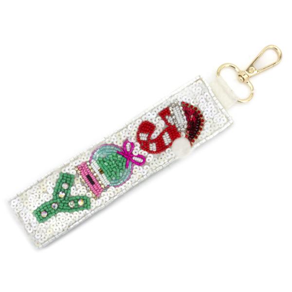 Christmas Spirit Keychains: Sequined keychain with Santa's face, a Christmas tree, and a gift design. Features an elegant gold clasp. Size not specified.