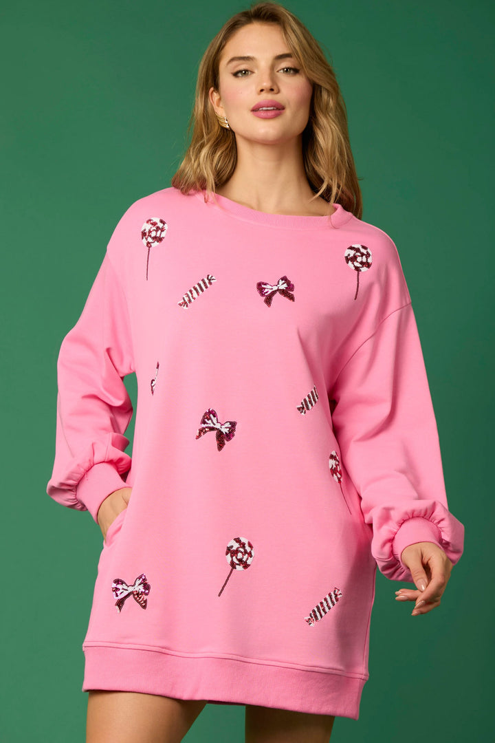 Pink festive long sleeve crew neck dress with sequined lollipop and bow patterns.