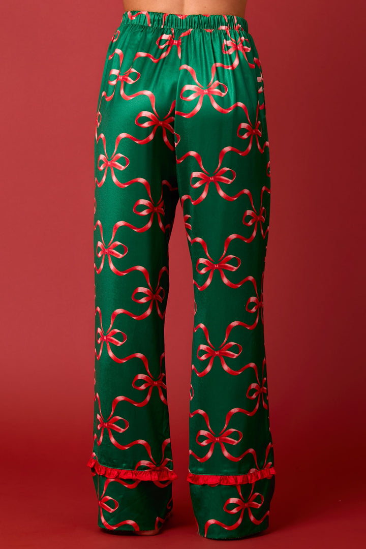 Green satin bow print tie-front long sleeve pajama set with ruffle detail and red ribbon bow print pants with ruffled hems.