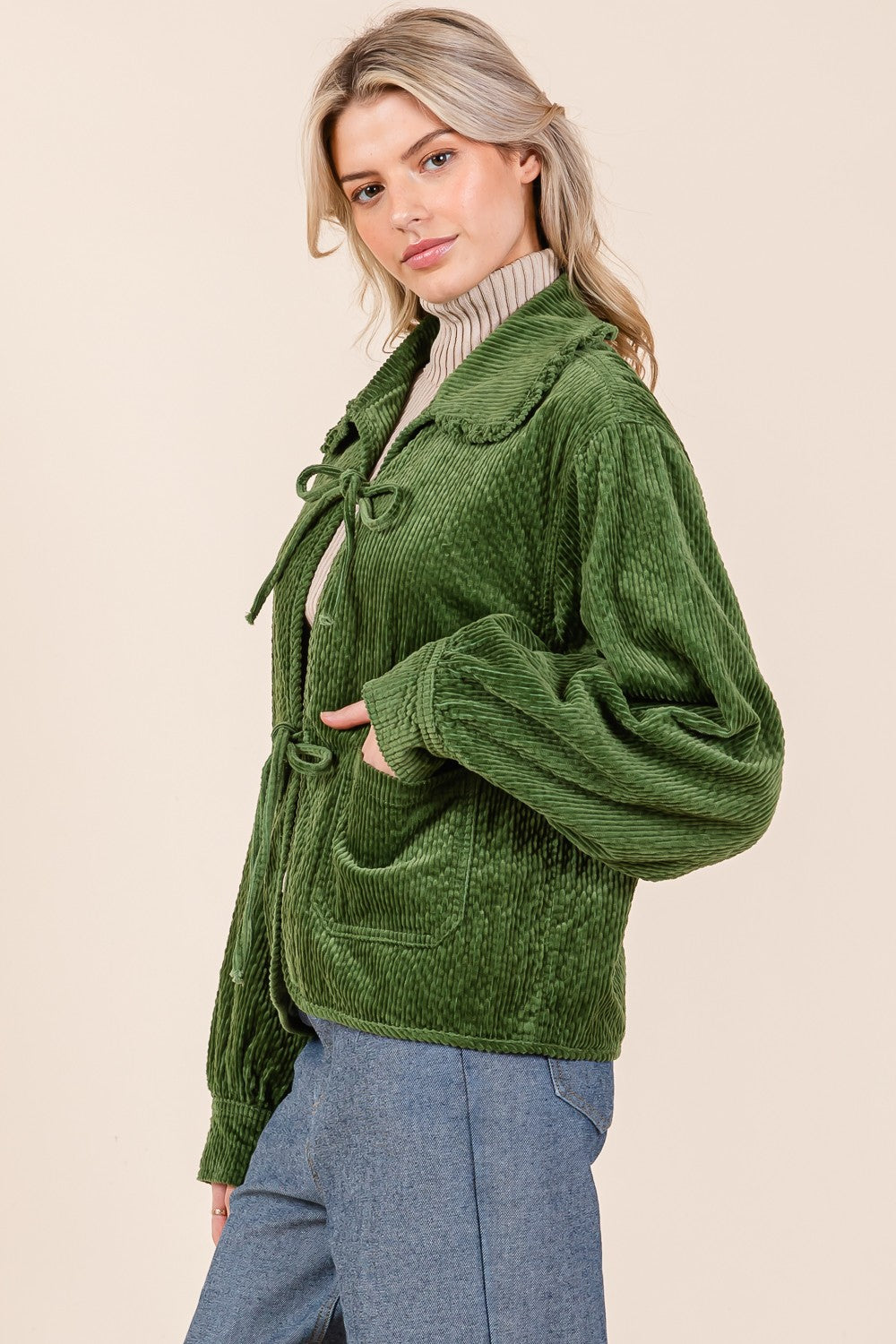 The Ruffle Charm Corduroy Jacket in green features a self-tie front closure and convenient pockets. Available in sizes XS to XL.