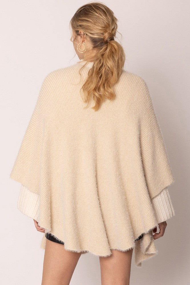 The Lurex Kimono Poncho features white sleeves and an elegant drape, showcasing its versatility. Available in one size fits most.