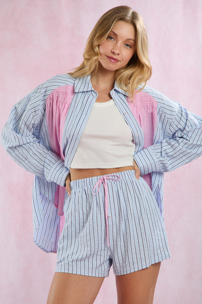 Blue and white striped lightweight summer shirt with pink accents, shirring detail, button up. Available in sizes XS-XL.