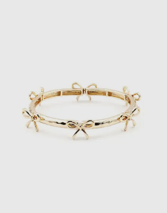 Gold stretch bracelet with evenly spaced small bow designs; available in one size fits most.