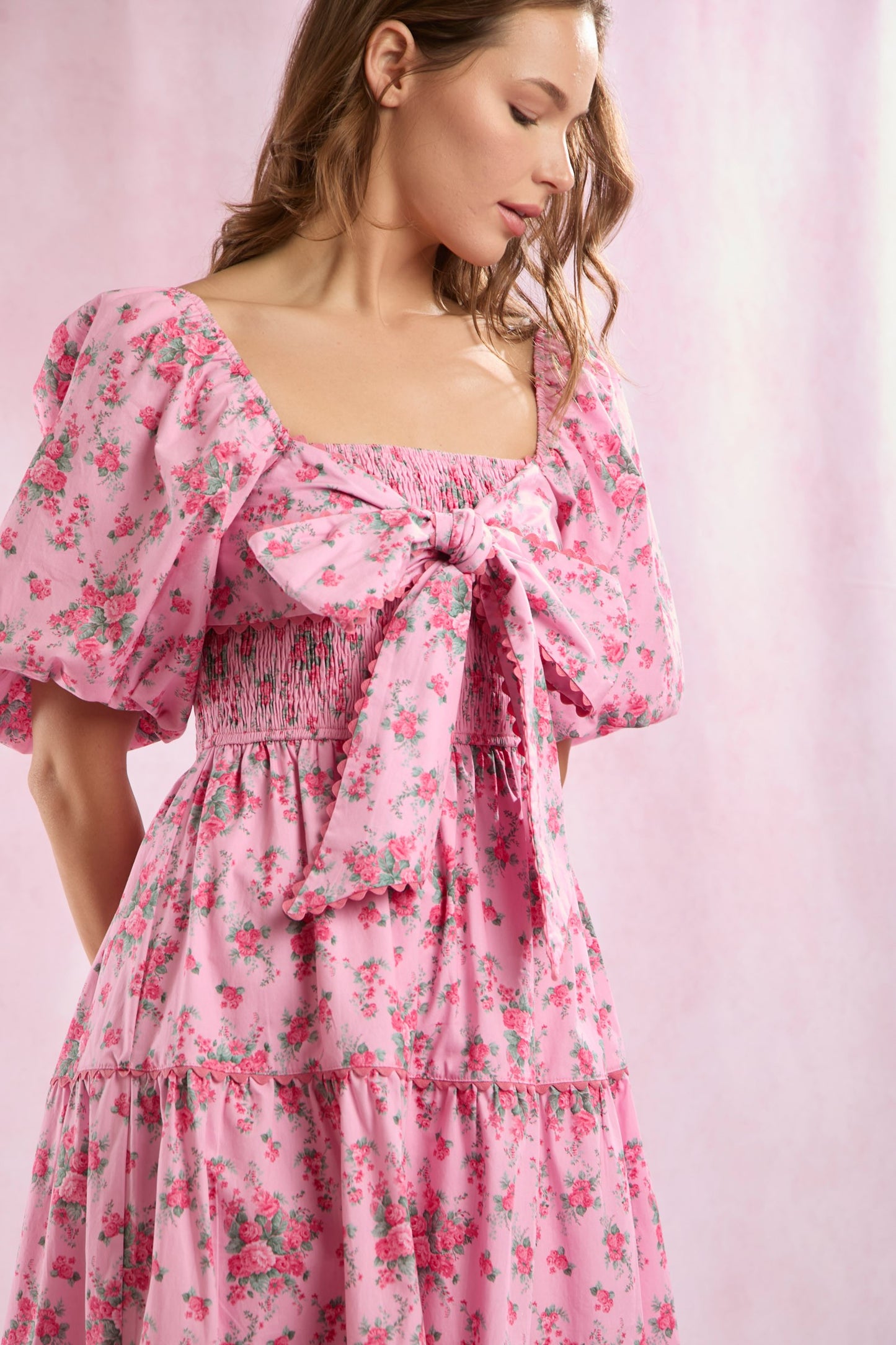 Bailey Floral Bow Front Maxi Dress in pink floral print with puffed sleeves, square neckline, and large bow detail. Available in sizes XS–XL.