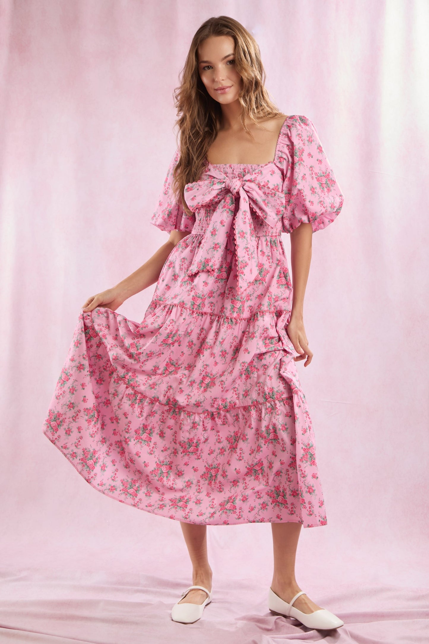 Bailey Floral Bow Front Maxi Dress in pink floral cotton poplin with puff sleeves and a tiered skirt. Sizes: XS, S, M, L, XL.
