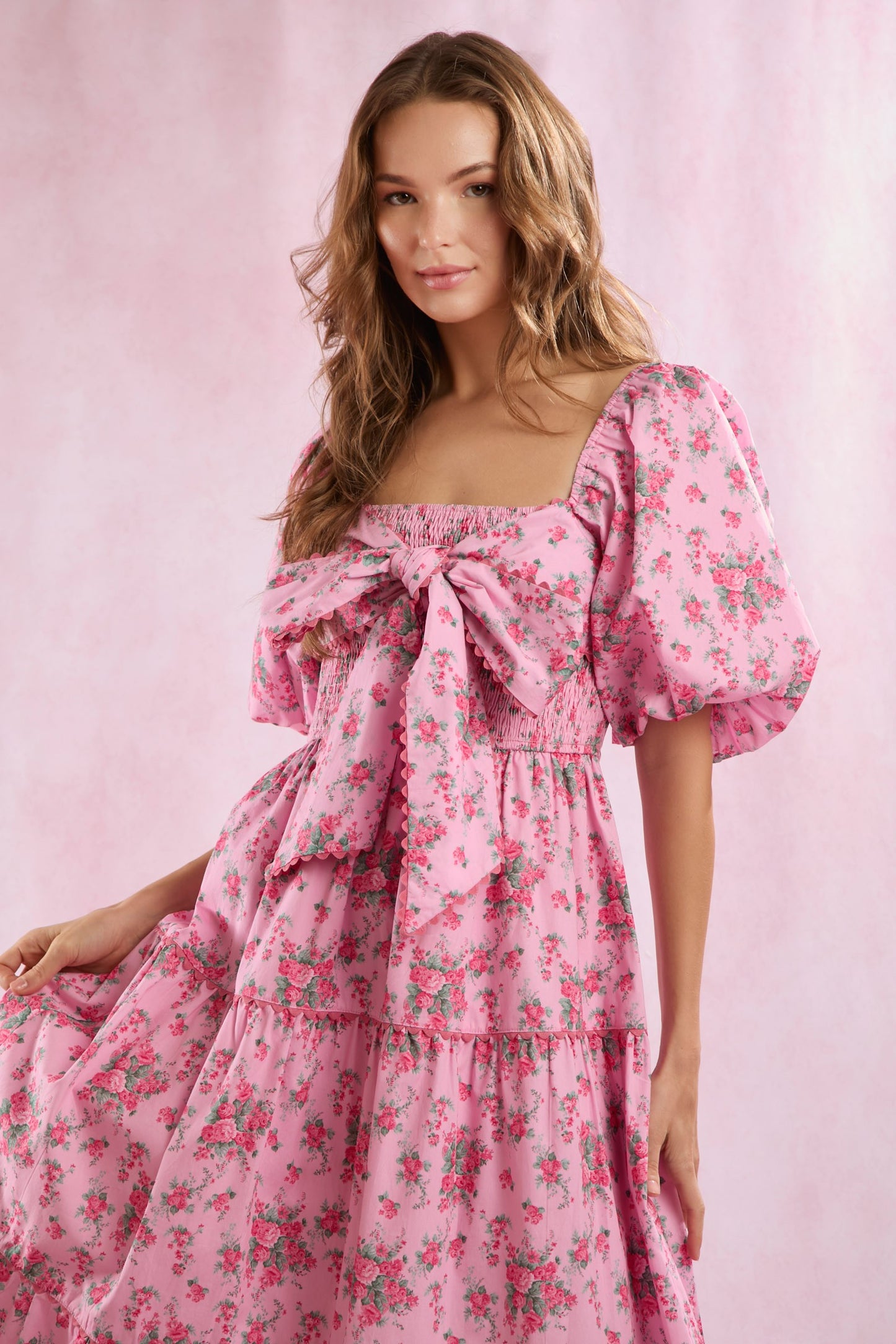 Bailey Floral Bow Front Maxi Dress features a vibrant floral print, bow detail at the front, and a flowing maxi-length silhouette. Available in sizes XS–XL.