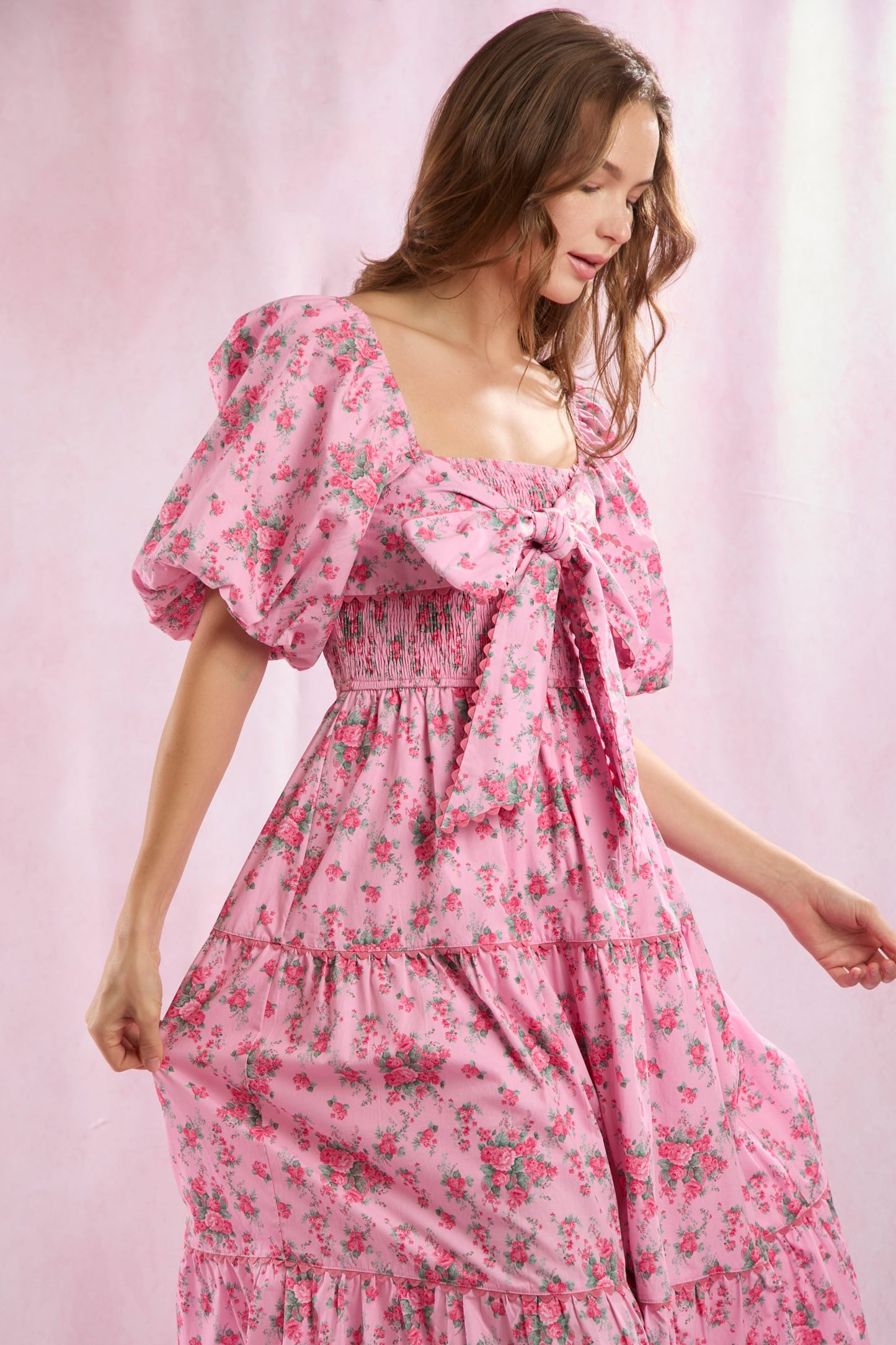 Bailey Floral Bow Front Maxi Dress with puff sleeves, pink floral pattern, and large front bow. Available in sizes XS-XL.