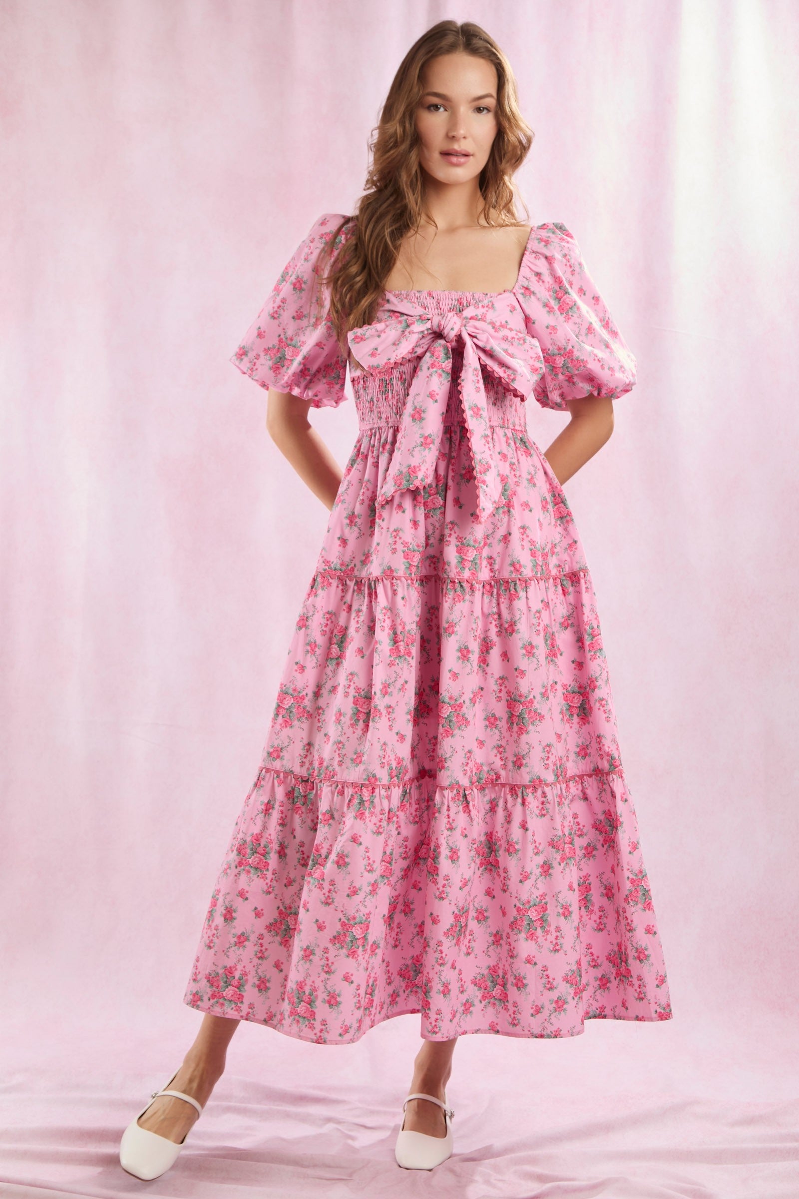 Bailey Floral Bow Front Maxi Dress features puffed sleeves, a bow on the bodice, and a flowing maxi skirt. Available in sizes XS–XL.