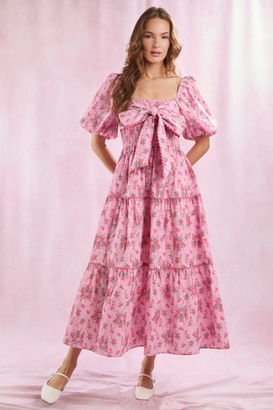 Bailey Floral Bow Front Maxi Dress features puffed sleeves, a bow on the bodice, and a flowing maxi skirt. Available in sizes XS–XL.