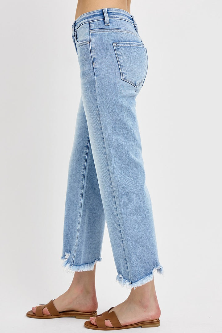 Risen Light Wash Mid Rise Crop Straight Jeans with distressed hem. Available in sizes 24-32.