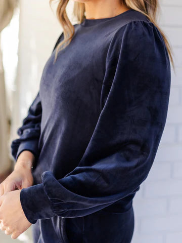 Chelsea Pullover: long-sleeve dark blue velour top with puff sleeves. Available in sizes XS–XL.