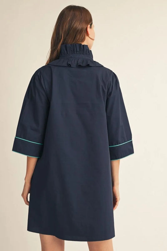 Cecilia Floral Embroidered Dress: loose-fitting navy mini dress with three-quarter sleeves, ruffled neckline, and floral embroidery. Available in sizes XS–XL.