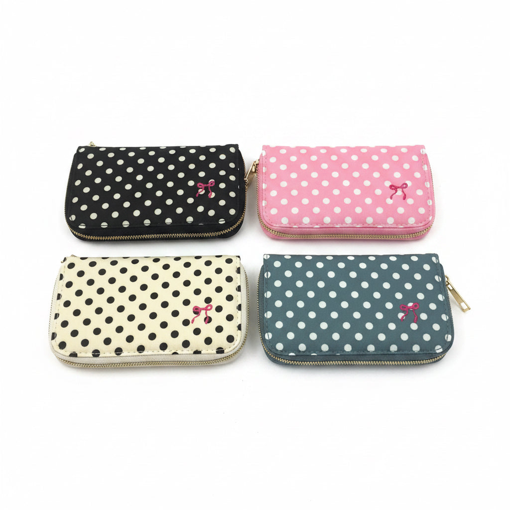 Set of four compact zippered pouches with polka dots in black, pink, cream, and blue, each featuring a small bow. Available in small, medium, large, and extra-large sizes.