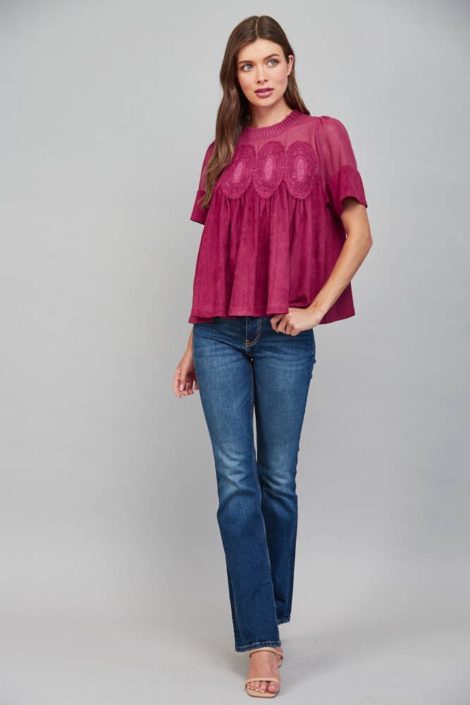 Teal blue short-sleeved top with sheer mesh upper panel, lace appliqué, and faux suede body.