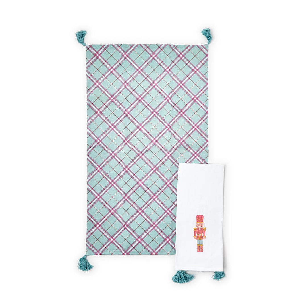 Nutcracker set of 2 dish towels with tassels, including one light blue and pink plaid towel and one white towel with a single Nutcracker illustration.