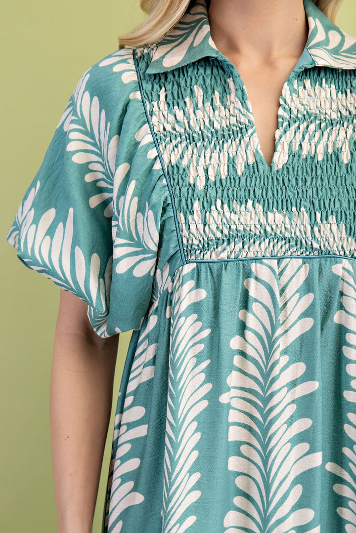 Teal midi dress with white leaf print, short puff sleeves, smocked chest, wide collar. Available sizes: XS-XL.
