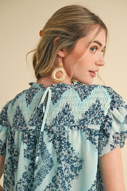 Teal Floral Smocked Yoke Ruffle Trim Top with smocked detailing and ruffle trim. Available in sizes XS-XL.