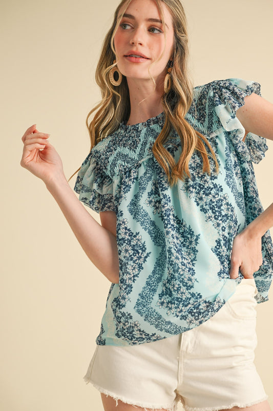 Teal Floral Smocked Yoke Ruffle Trim Top, available in sizes XS-XL.