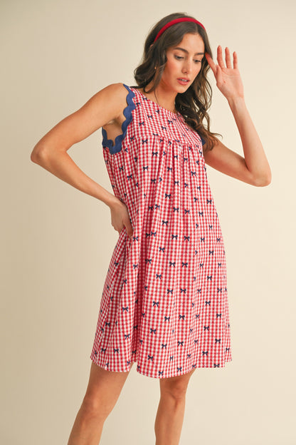 Miss Americana Bow Print Dress: Sleeveless red and white gingham with blue scalloped trim, bow print, pockets. Sizes: XS, S, M, L, XL.