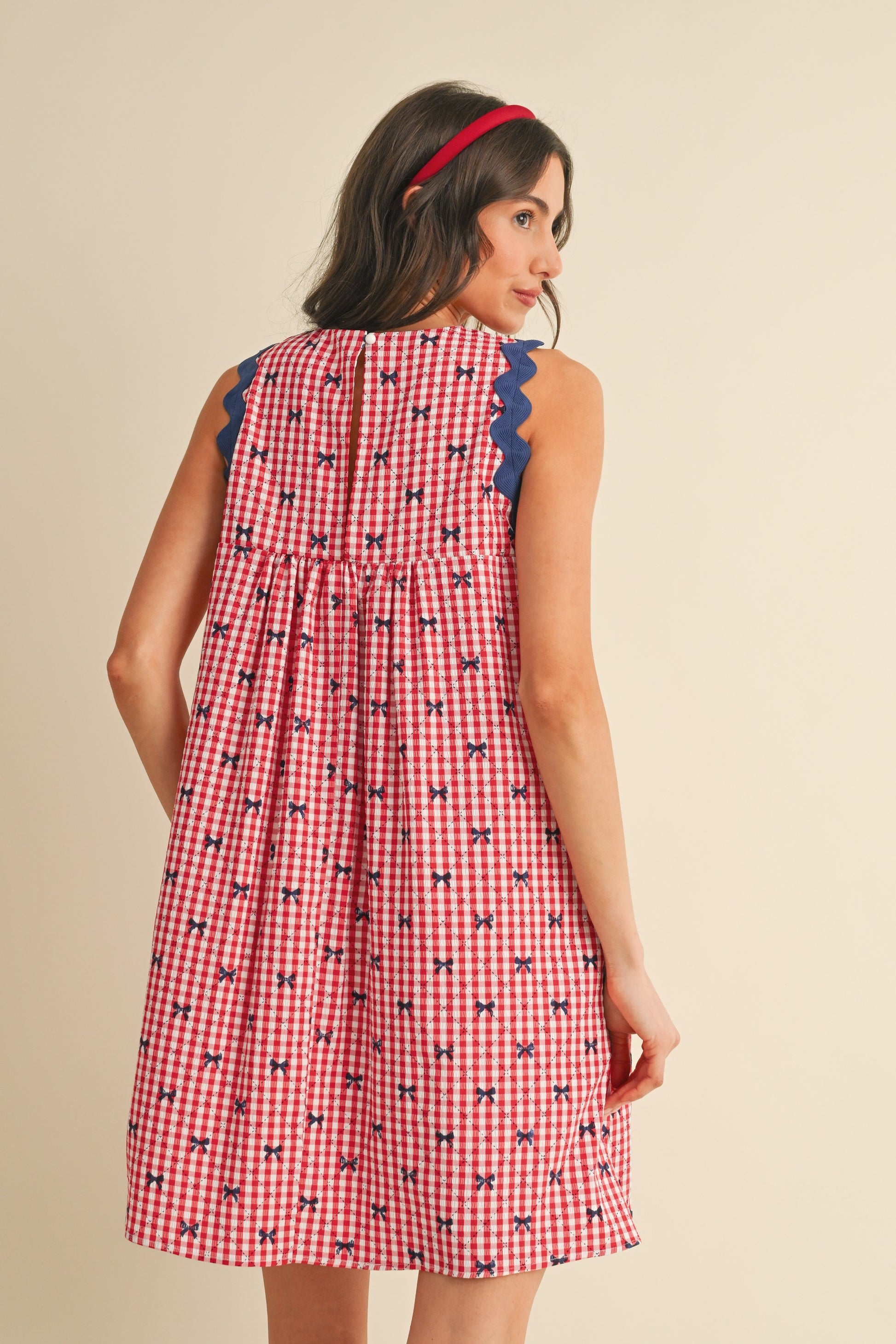 Miss Americana Bow Print Dress: Sleeveless, bow print design, red accent at the collar. Sizes available: XS, S, M, L, XL.