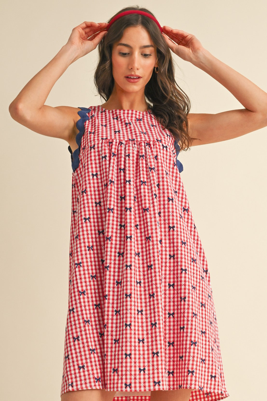 Miss Americana Bow Print Dress in red and white gingham with blue scalloped trim and small floral motifs. Available in sizes XS–XL.