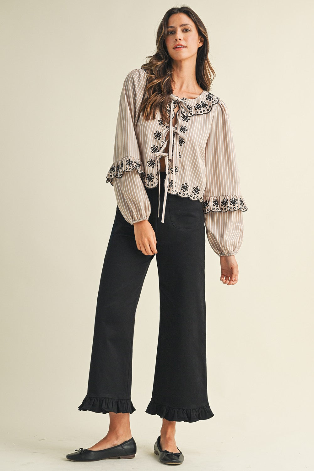 High-rise black ruffle hem cropped pants in stretch cotton twill; available in sizes XS-XL.