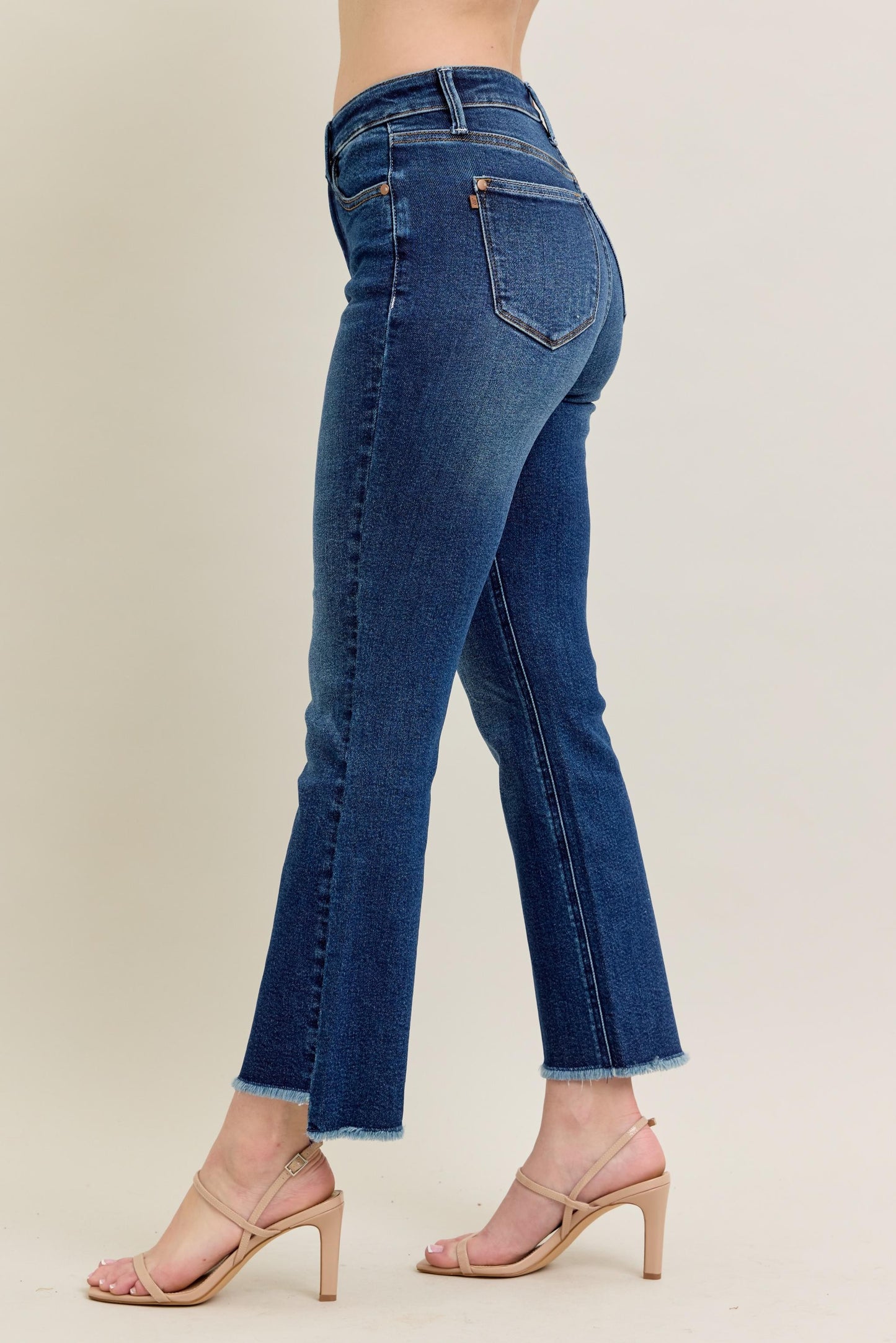 Judy Blue HW Dark Wash Kick Flare Jeans feature a raw hem, subtle tummy control, and a flattering silhouette. Available in sizes 0-20W.