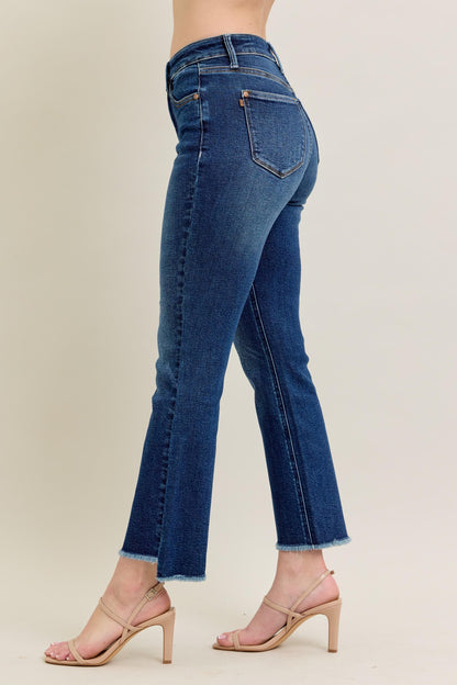 Judy Blue HW Dark Wash Kick Flare Jeans feature a raw hem, subtle tummy control, and a flattering silhouette. Available in sizes 0-20W.