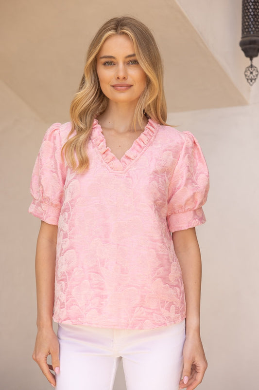 Light pink Poppy Ruffled V-Neck Floral Top with short sleeves, ruffled neckline, textured details. Available in XS–XL.