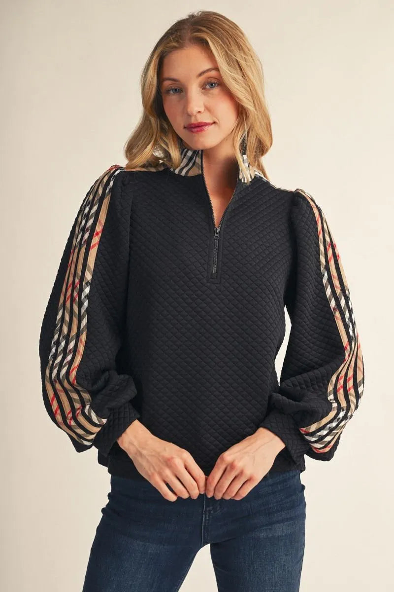 Black Long Sleeved Plaid Zip Up Top: casual, lightweight pullover with textured black body, plaid puffed sleeves, quarter-zip collar. Available in sizes S–XL.