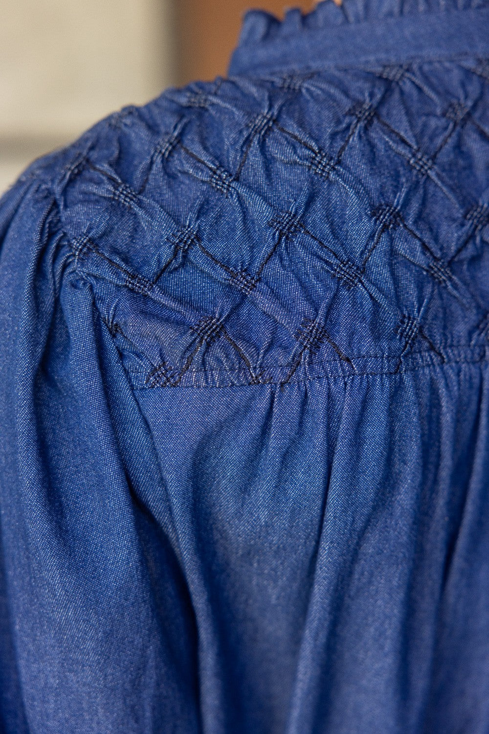Diamond Textured Yoke Puff Sleeve Top in blue denim with diamond smocking detail. Available sizes: XS-XL.