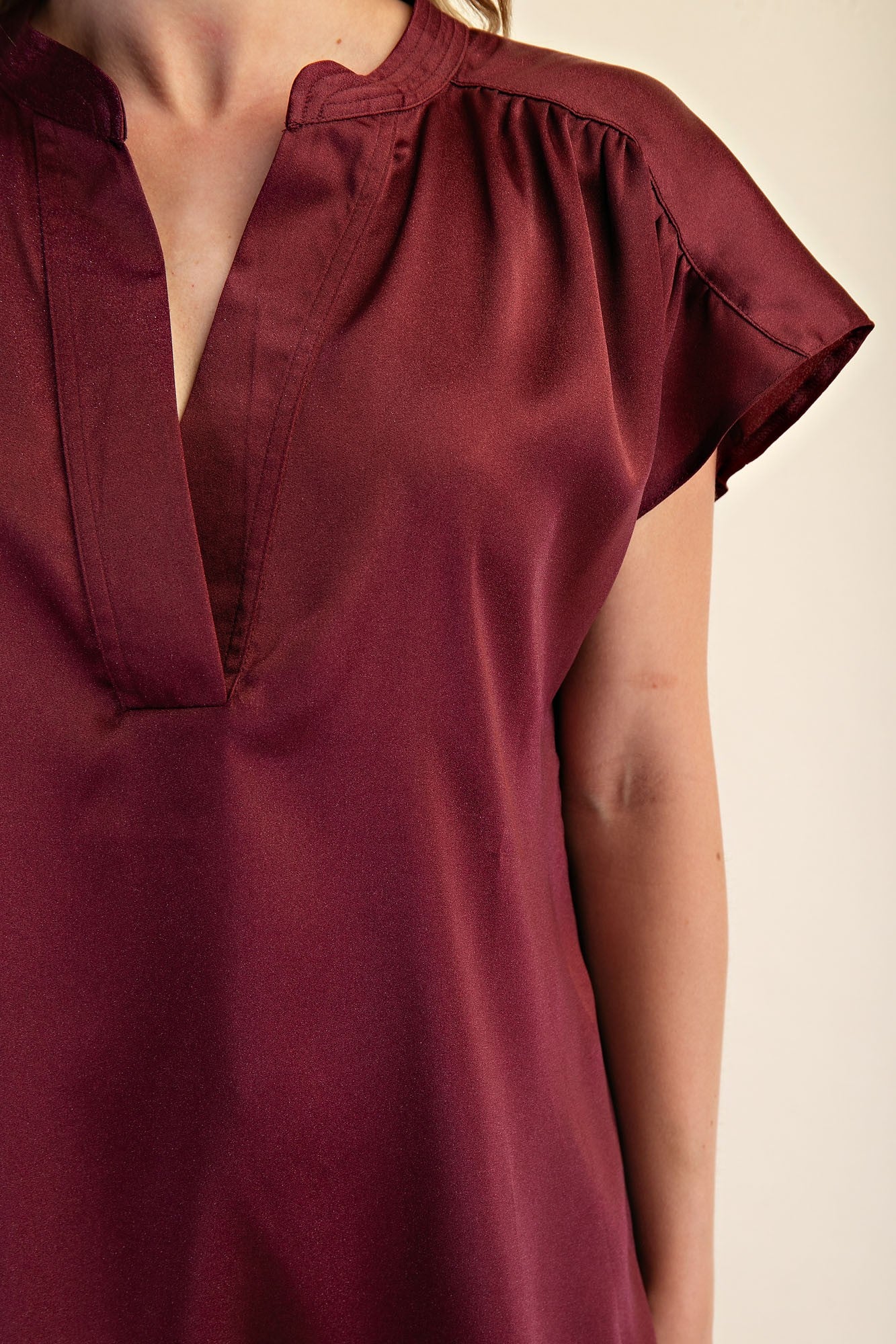 Jami Drop Cap Sleeve Satin Blouse in burgundy with short sleeves, v-neck, gathered shoulders. Available in XS-XL.