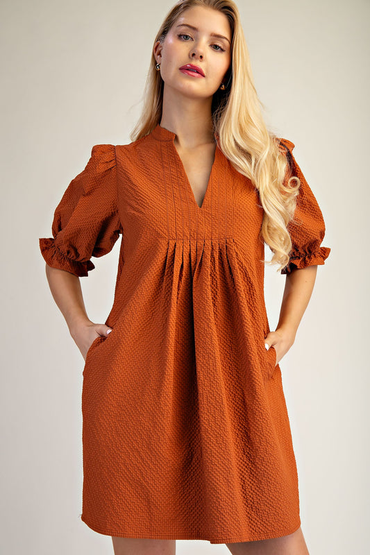 Lyla Puff Sleeve Dress: rust-orange, v-neck, textured fabric, 3/4 puff sleeves, pockets. Sizes XS-XL.
