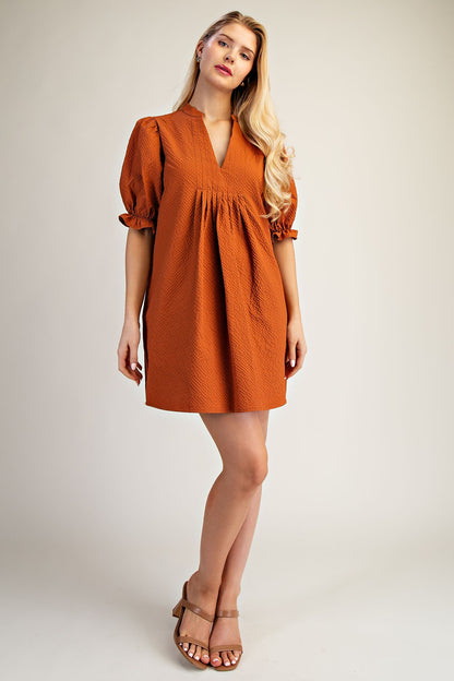 Lyla Puff Sleeve Dress in rust-orange, short length, textured, V-neckline, puff sleeves. Available in sizes XS-XL.