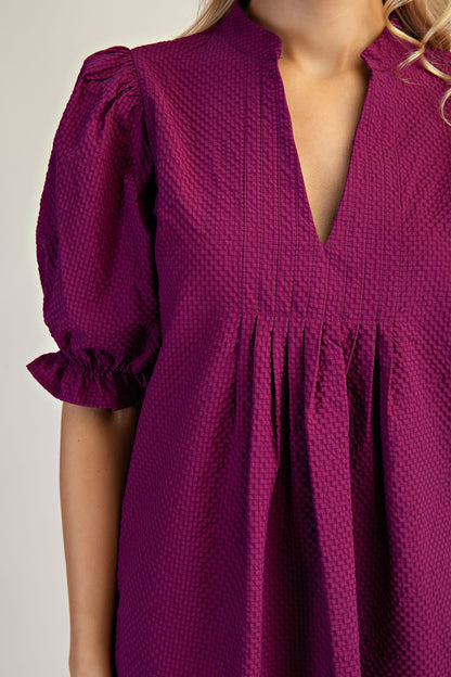 Lyla Puff Sleeve Dress in textured deep purple with short ruffled cuffs and deep V-neckline. Available in sizes XS-XL.