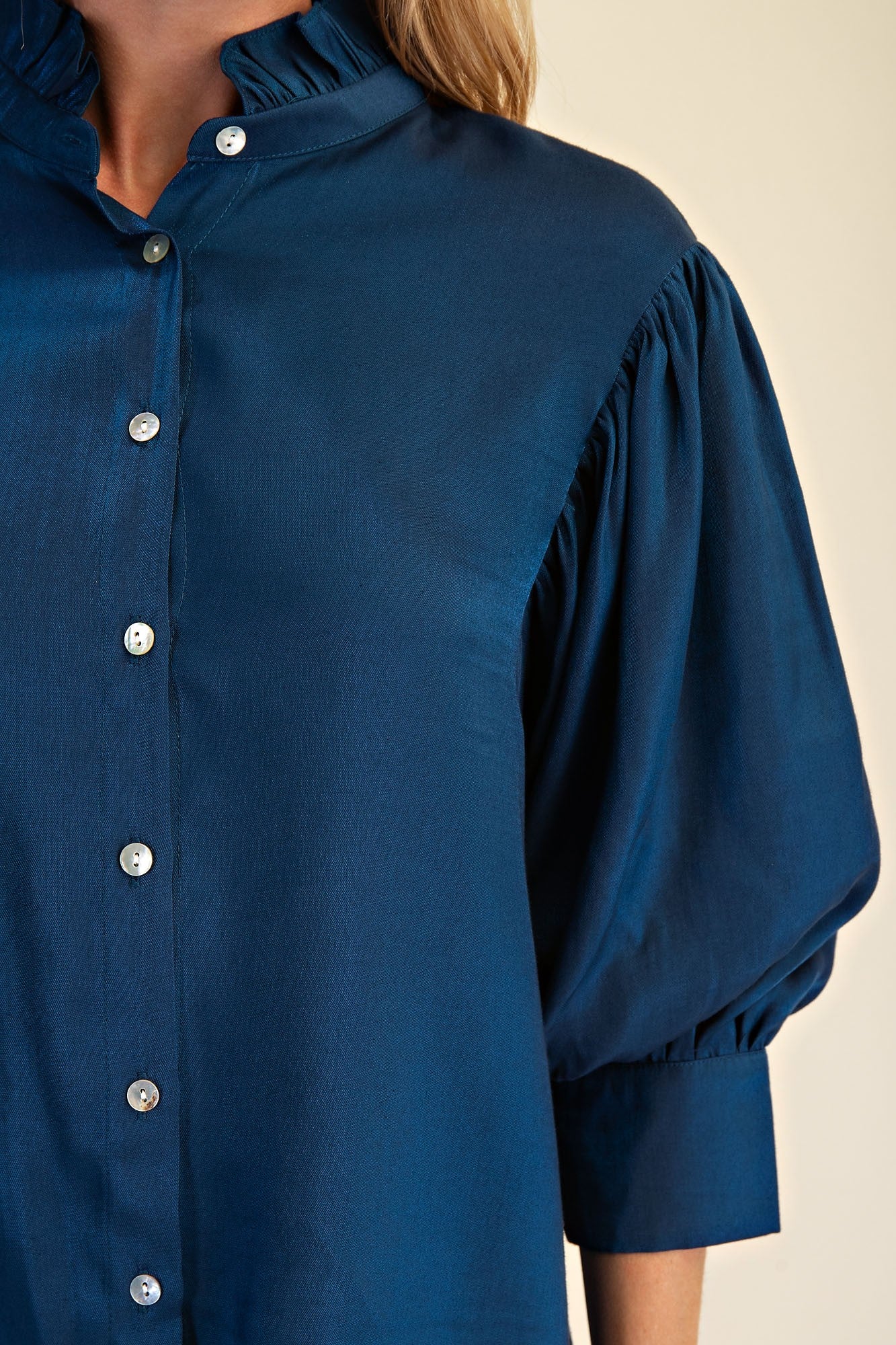 Peacock Blue Ruffle Neck Puff Sleeve Blouse with puffed 3/4 sleeves and shiny buttons. Available in sizes XS–XL.