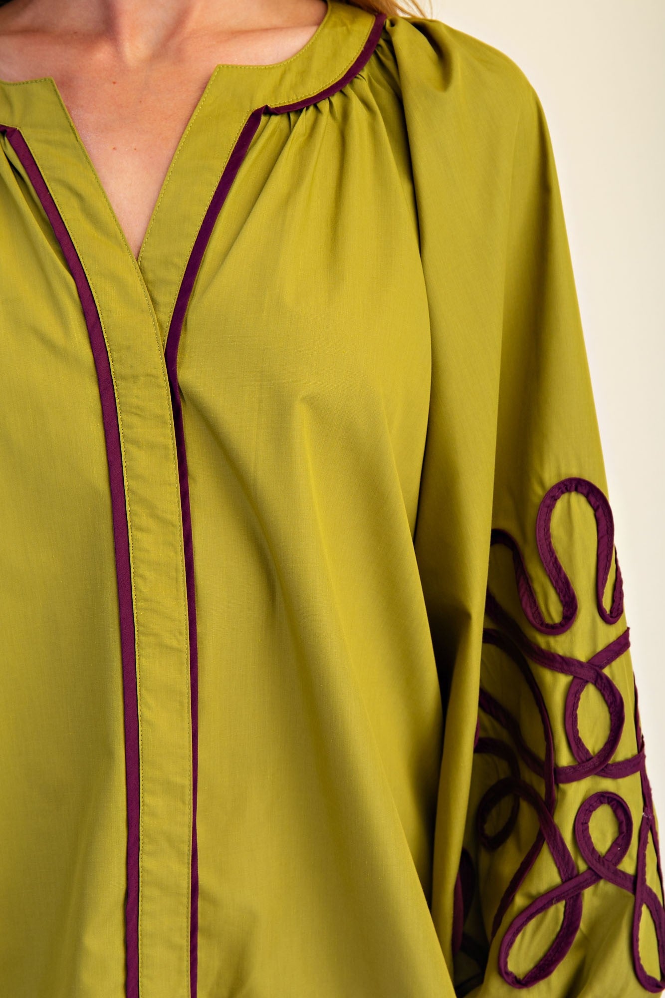 Chartreuse blouse with purple trim, soutache detail, gathered neck, balloon sleeves. Available in sizes XS-XL.