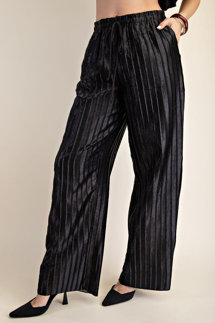 Pitch Flowy Pants: high-waisted black satin wide-leg pants with vertical stripes, drawstring waist. Sizes XS-XL.