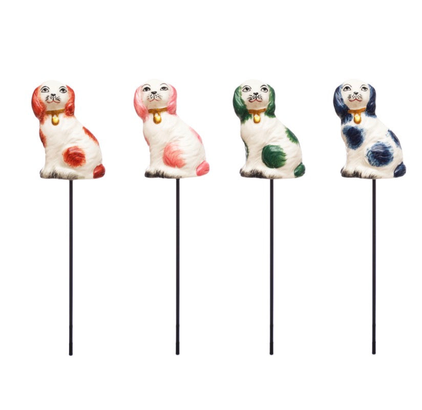 Set of four stoneware dog shape plant stakes with red, pink, green, and blue markings and small gold collars. Available in one size.