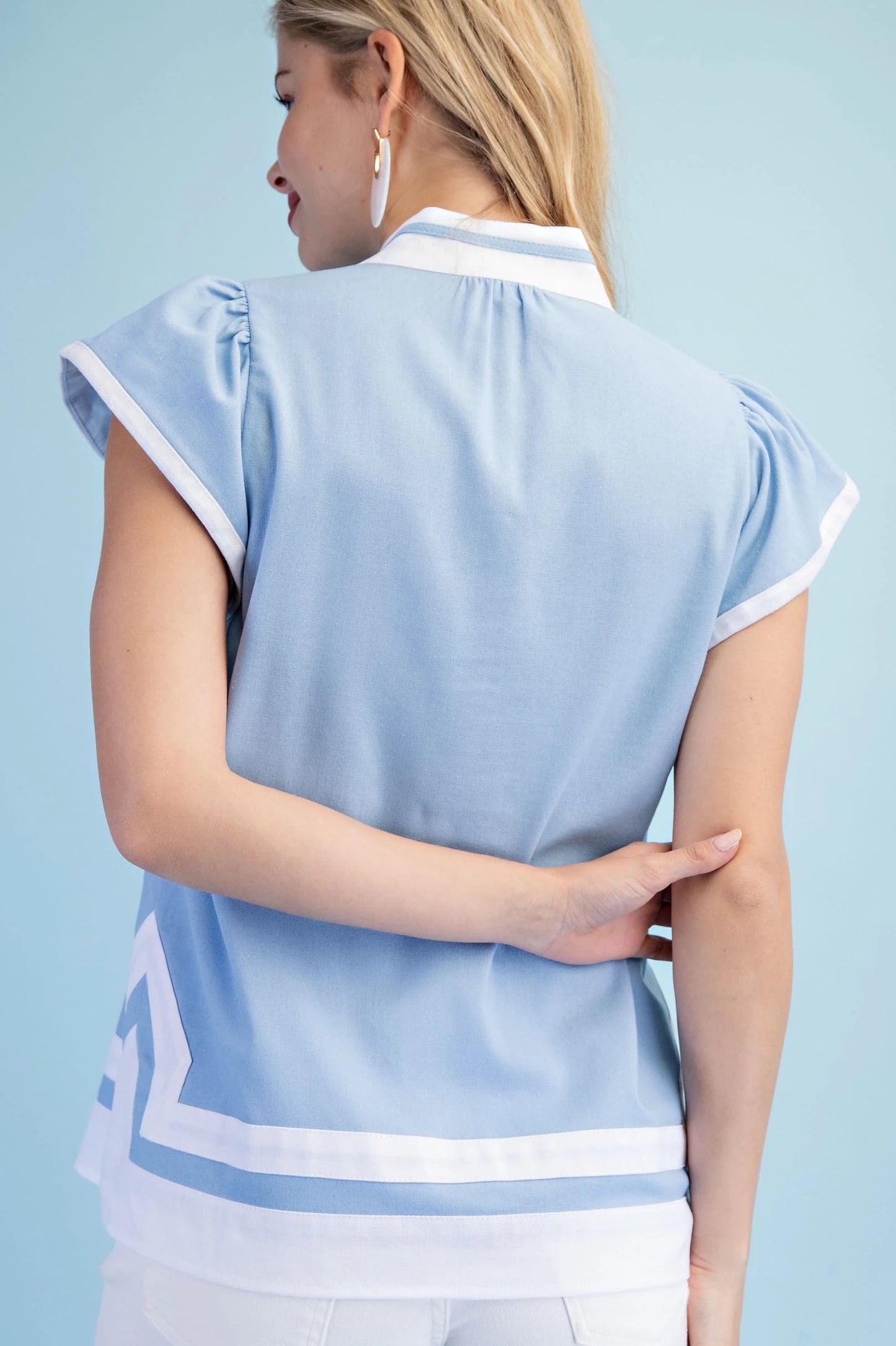 Light Blue Embroidered Appliqué Design Top with white trim, available in sizes XS-XL.