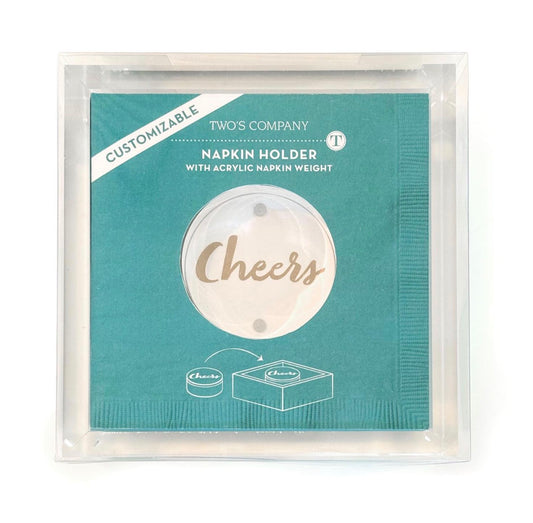 Turquoise package labeled “Acrylic Cocktail Napkin Holder with Paper Weight” and a round window showing “Cheers” on the acrylic weight. Sizes available: not specified.