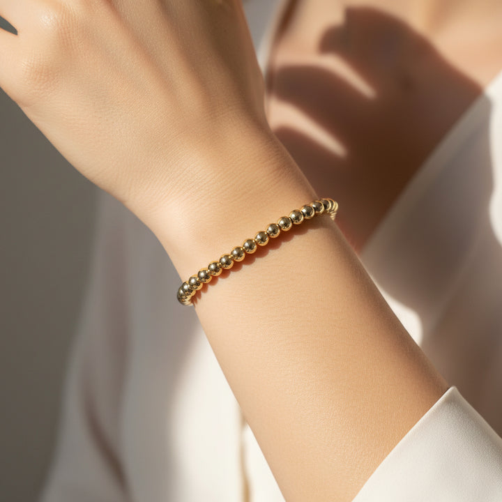 Water-resistant stretch bracelet with shiny metallic beads. Available in sizes S, M, and L.