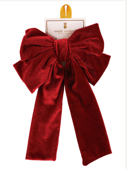 Large deep red velvet bow with long tails, gold hanging loop, on Simply Southern card. Available in one size.