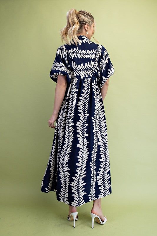 Navy blue midi dress with white fern leaf pattern and short puff sleeves. Available in all sizes.