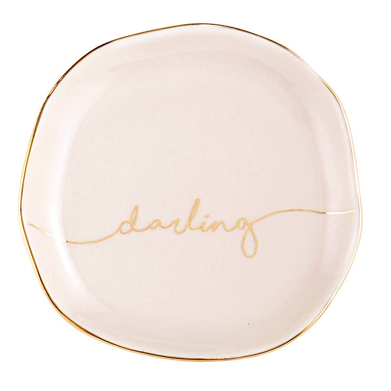 Cream round ceramic trinket tray with thin gold rim, "darling" in gold cursive. Size: one size.