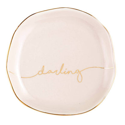 Cream round ceramic trinket tray with thin gold rim, "darling" in gold cursive. Size: one size.