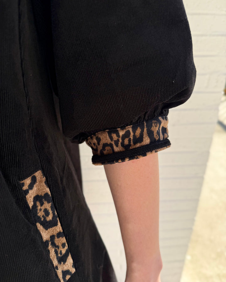 V-Neck Contrast Dress: black V-neck shift dress with puff sleeves and leopard-print trim on the cuffs and side pockets. Available in all sizes.