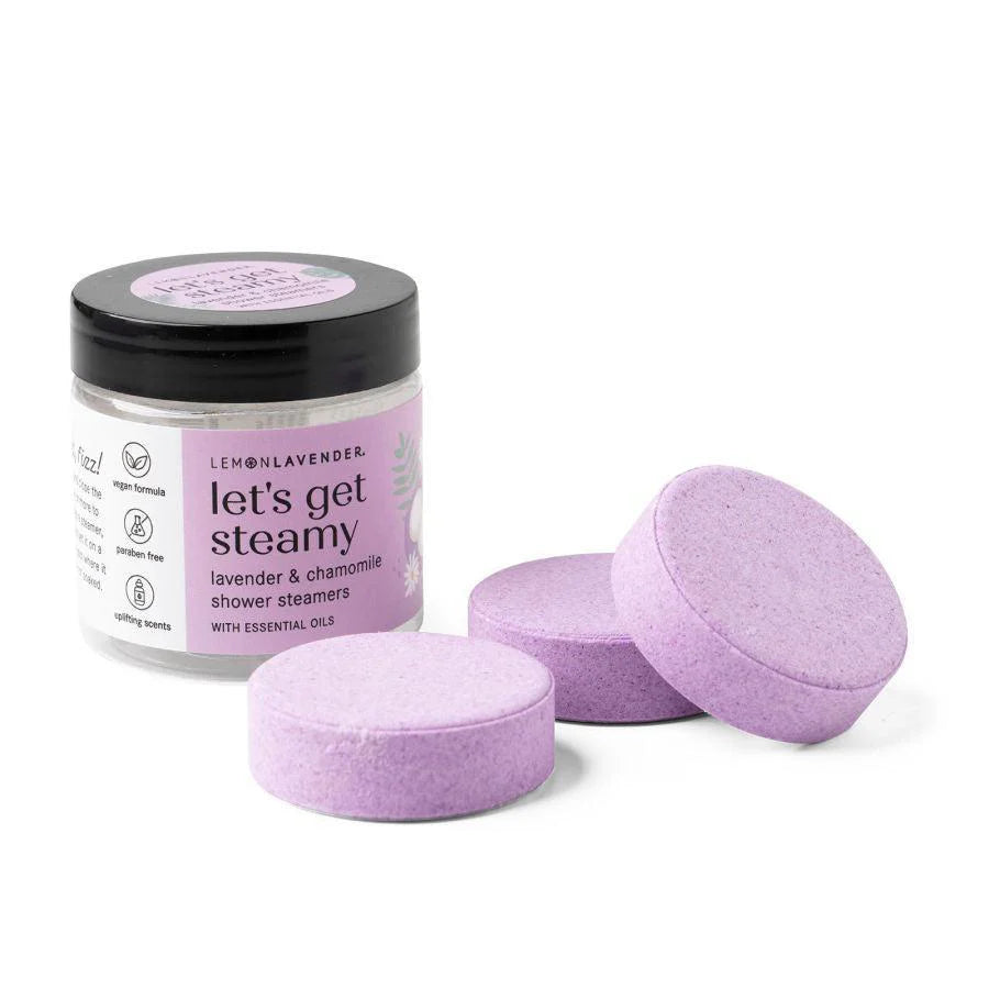 Let’s Get Steamy Shower Steamers Lemon Lavender in a labeled jar, round purple steamers, available in small and large sizes.