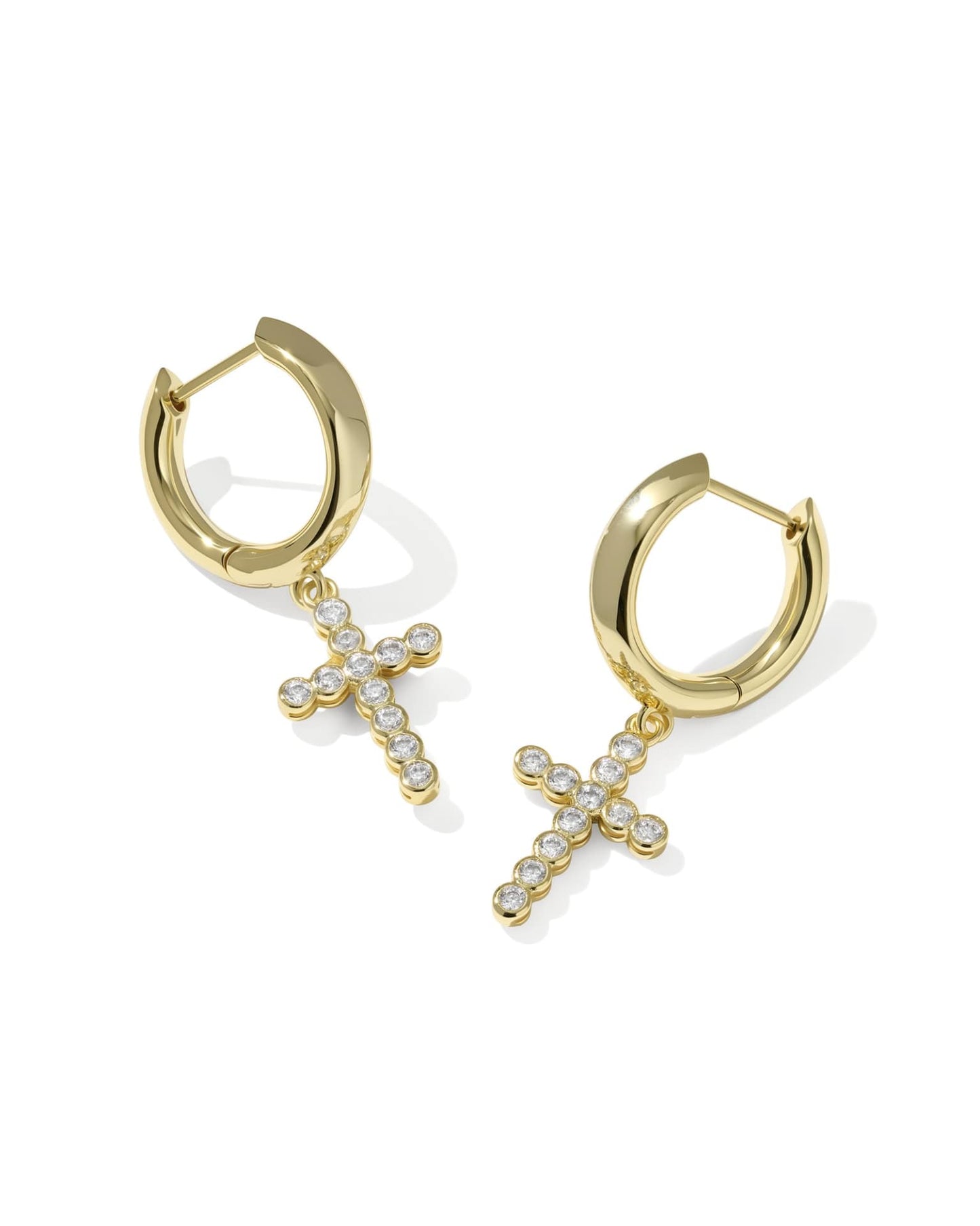 Gold huggie earrings with dangling cross charms, detailed with small clear crystals. Available in S, M, and L sizes.