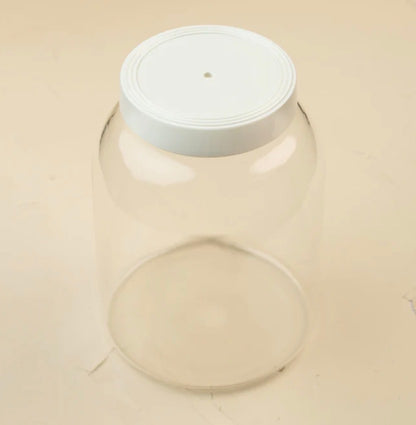 Large clear customizable kitchen canister with white screw-on lid featuring a small center hole; available in multiple sizes.